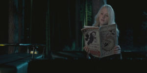 Luna reading The Quibbler upside down