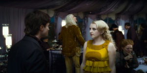 Luna in a yellow dress and the back of Harry
