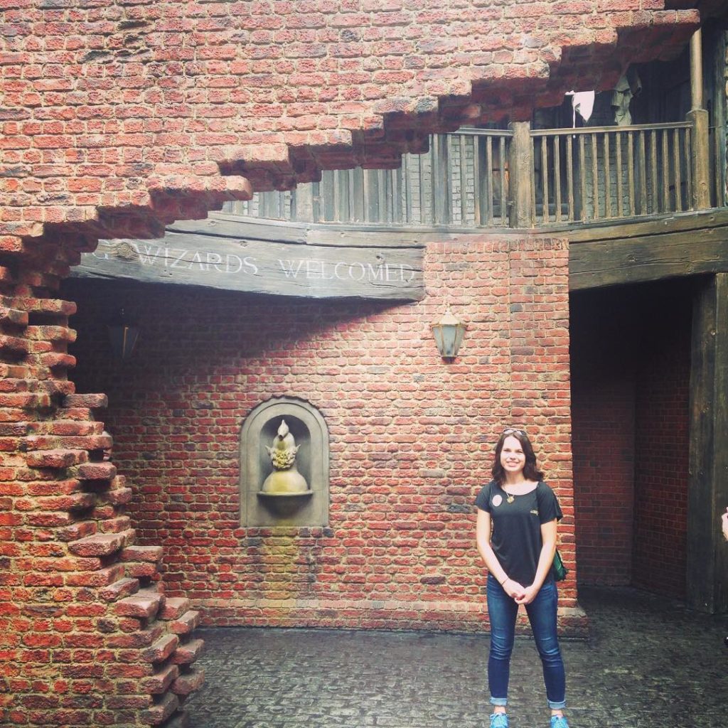 Amy standing under the archway into Diagon Alley