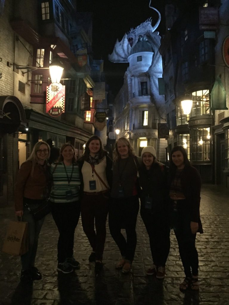 six people standing in front of the dragon on top of Gringotts