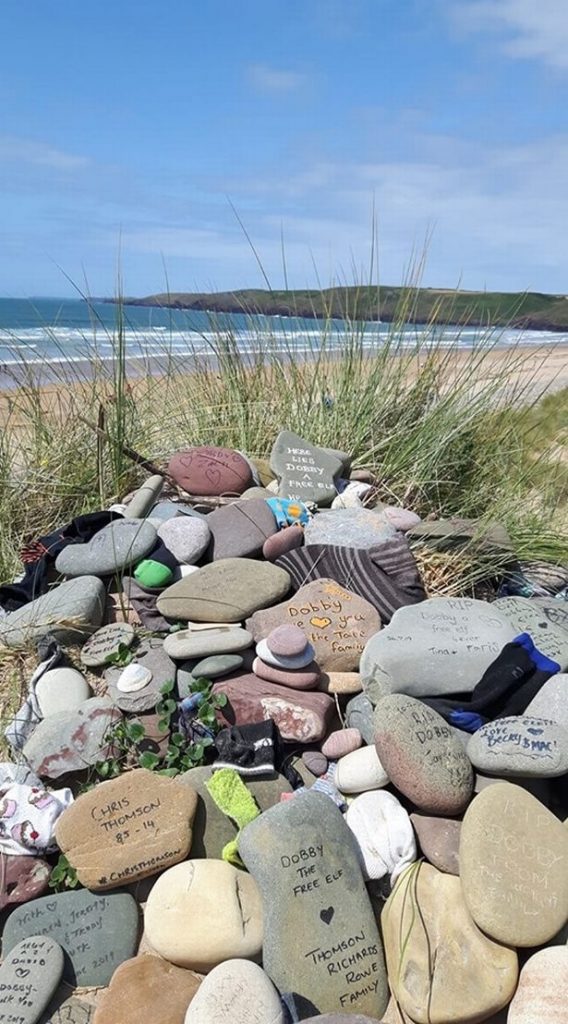 Dobby's grave site is covered in tributes from fans, stones reading messages and socks. 