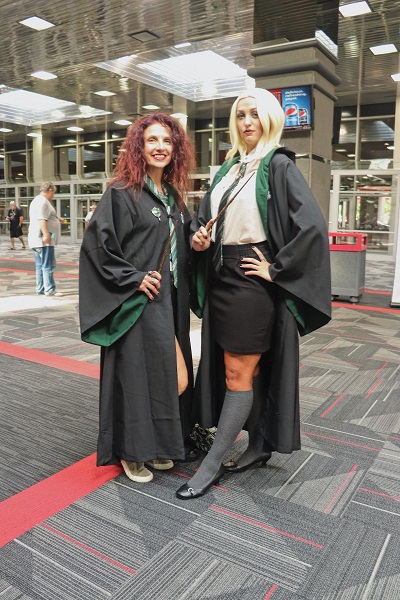 These cosplayers pose in the brightly lit lobby in Slytherin robes.