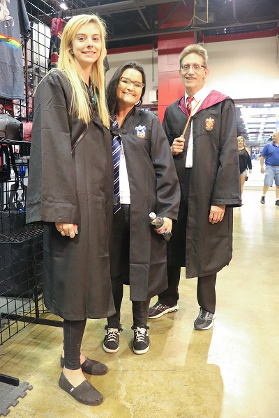 Three cosplayers dressed in Hogwarts robes.