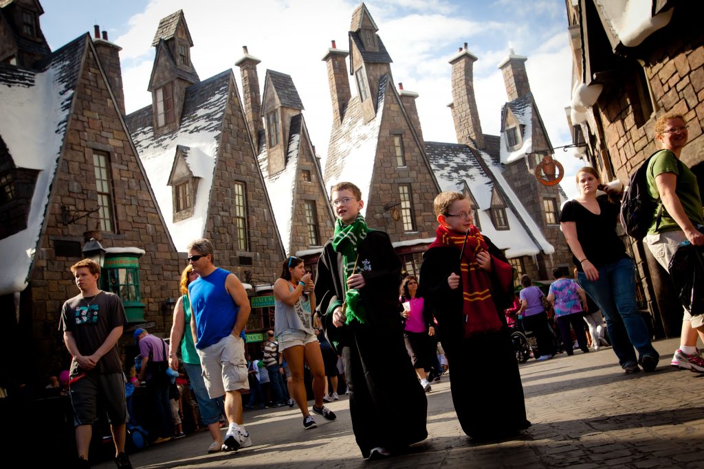 A pair of youngsters walk the streets of Hogsmeade, decked out in their House robes, at the Wizarding World of Harry Potter at Universal Orlando Resort.