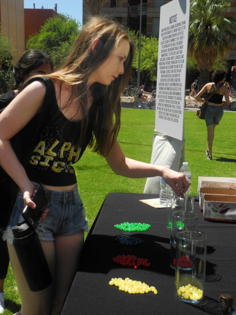 A University of Arizona student votes for her House with a Jelly Belly bean.