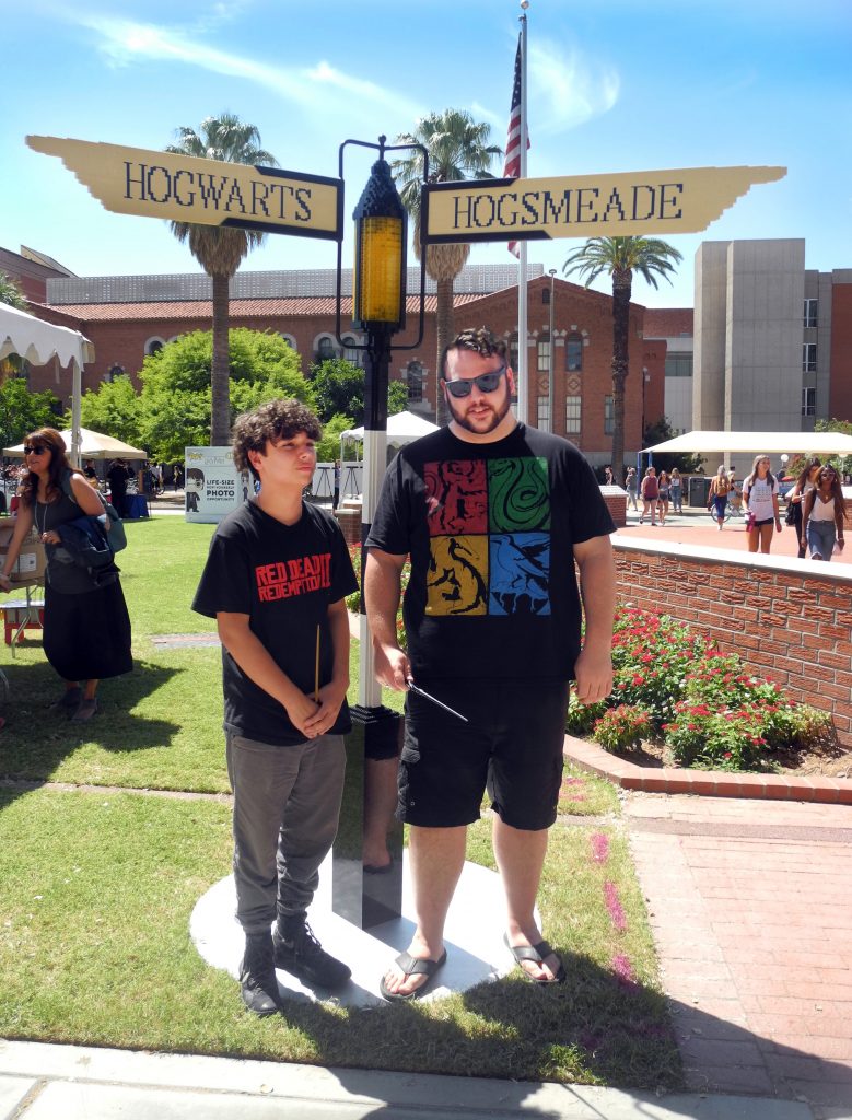 A pair of University of Arizona students poses for a photo in front of a signpost constructed from LEGO bricks.