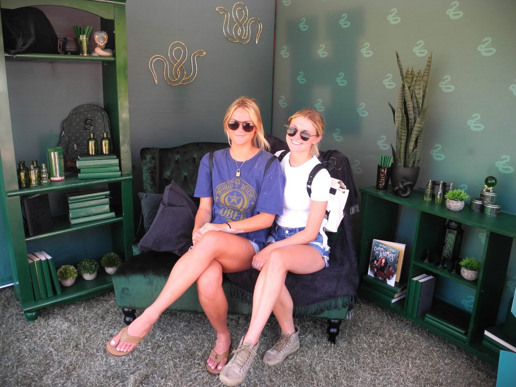 Two University of Arizona students pose in a miniature Slytherin common room during a Back to Hogwarts event at the school.
