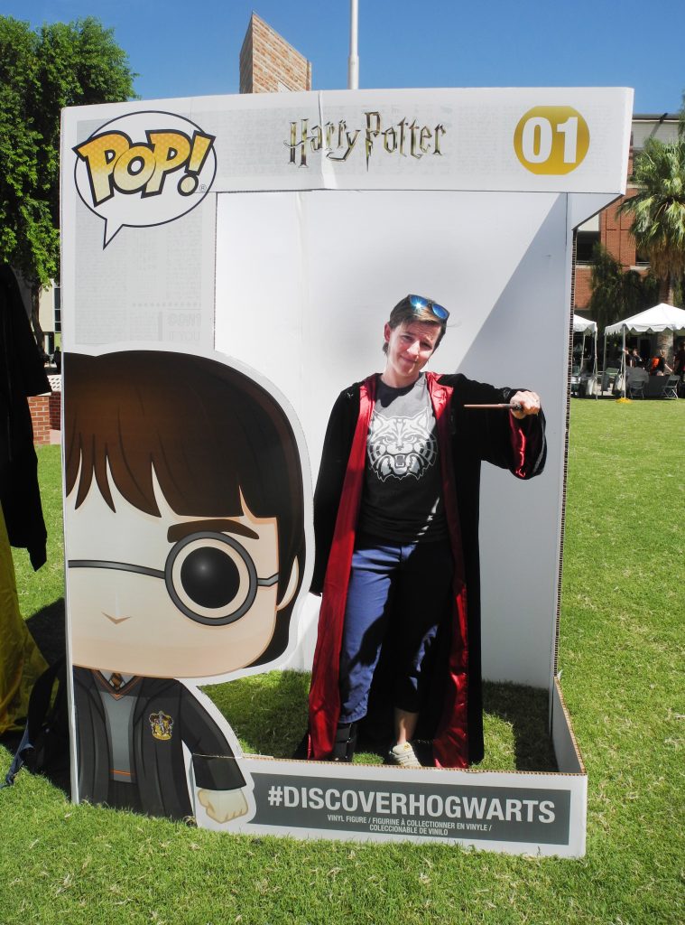 A University of Arizona student poses with a Gryffindor robe and wand in a life-sized Funko Pop! box during a Back to Hogwarts event at the school.