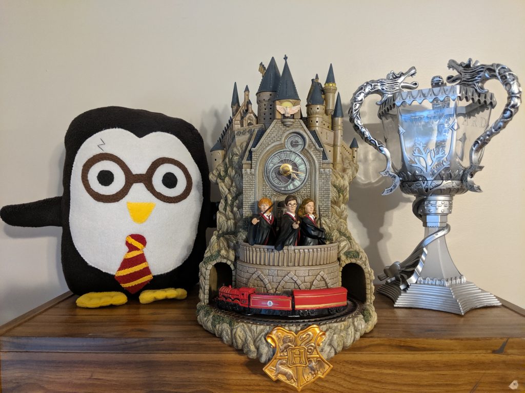 The Hogwarts wall clock next to a Harry Potter penguin and a Triwizard Cup