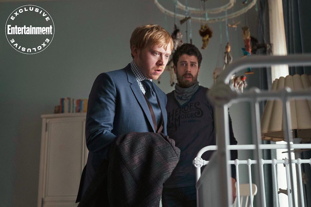 Rupert Grint and Toby Kebbell stare into a baby's crib in a still from the upcoming Apple TV+ series, "Servant".