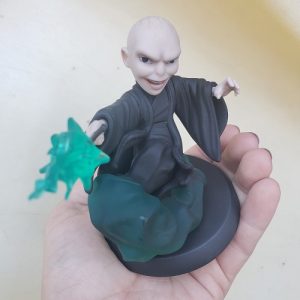 Image of Lord Voldemort Q-Fig up close to show details in face, held in a light skinned hand against a beige backdrop