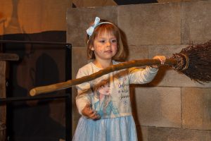 Photo of five year old girl holding a broomstick in front of her 