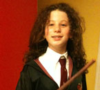 Tracy in Gryffindor robes weilding a wand