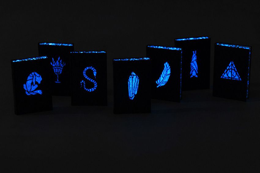potter books displayed in the dark. The pages and the cover images glow blue