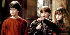Harry and Ron look on, shocked, as Hermione grimly points her wand at someone off-screen