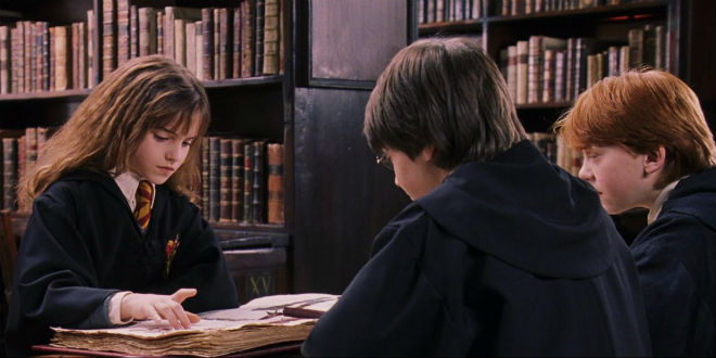 Harry, Ron, and Hermione reading in the library
