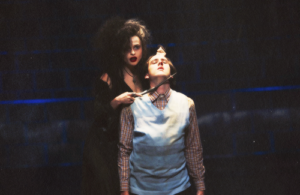 Bellatrix holding a wand to Neville's throat