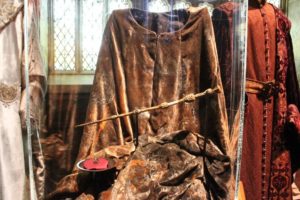 the elder wand displayed in front of harry potter movie costumes