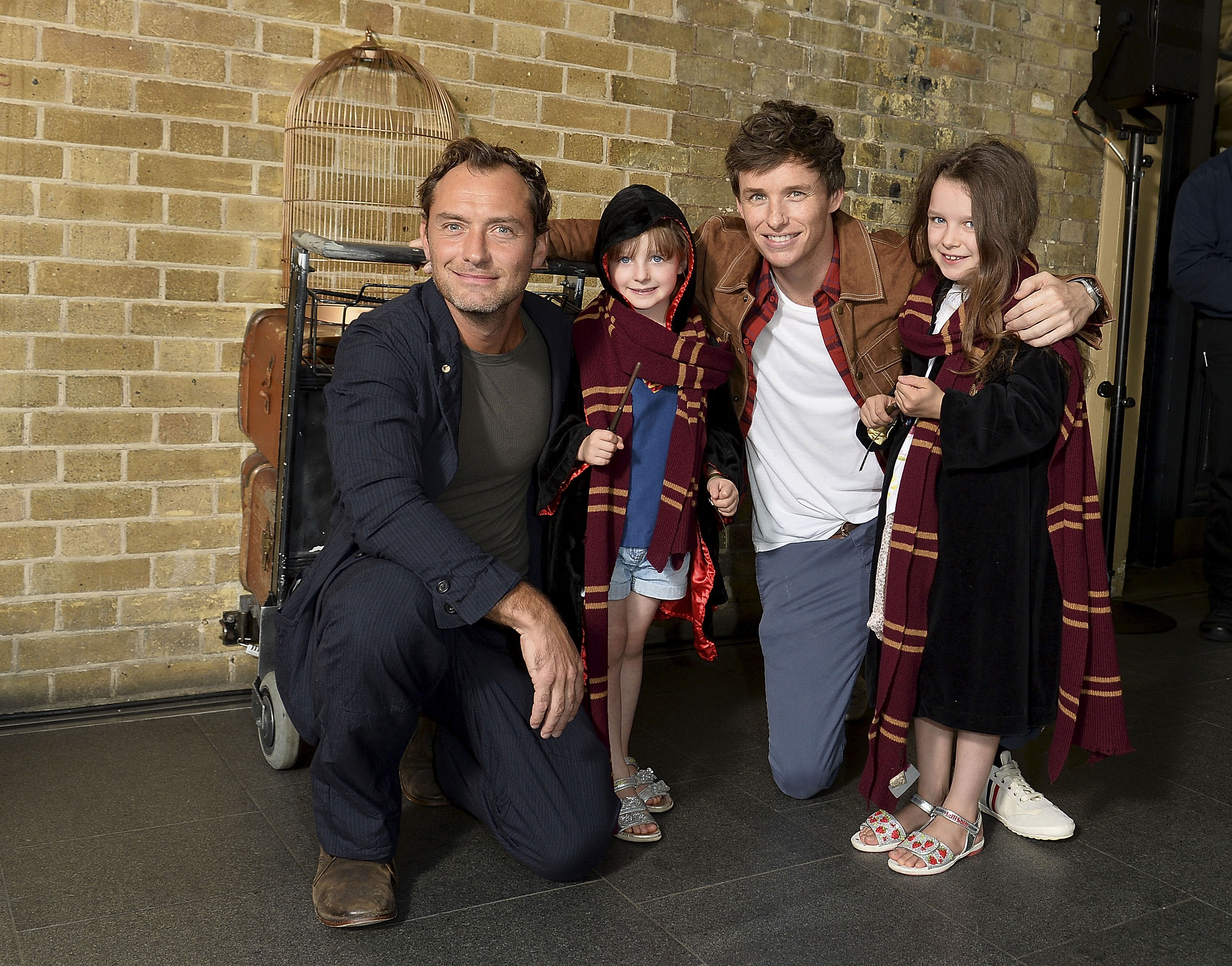 Two adorable young Gryffindors smile for a photo with Law and Redmayne in front of the trolley at Platform 9 3/4.