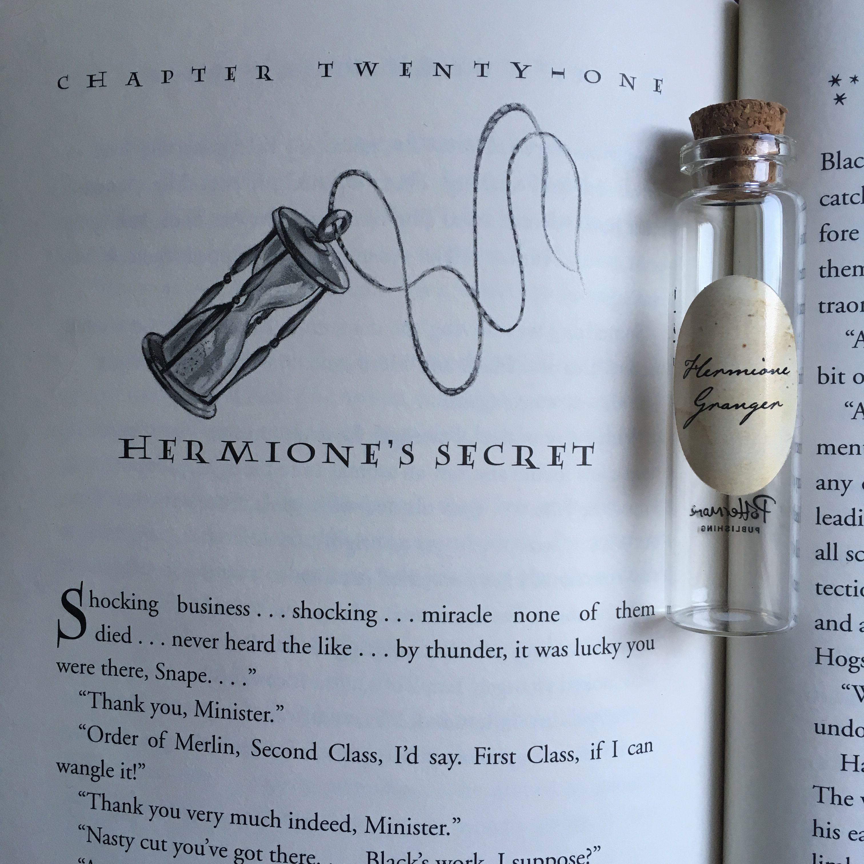 Hermione Granger’s Pensieve vial lying on top of the first page of Chapter 21, “Hermione’s Secret,” in “Harry Potter and the Prisoner of Azkaban”