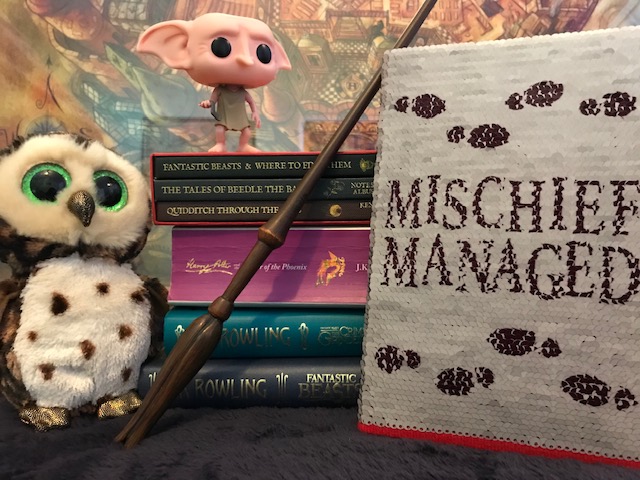 Harry Potter: Manage Your Mischief Marauder’s Map Sequin Notebook displayed with “Harry Potter” books, wand, owl, and Dobby figurine