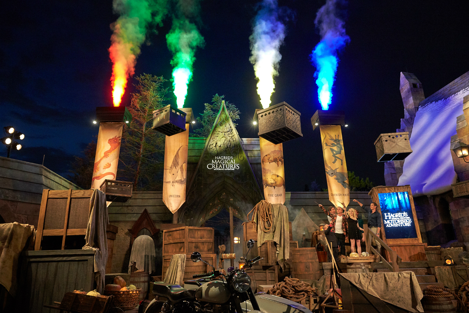 With the help of the Levitation Charm, the objects blocking the entrance to the ride are lifted out of the way as jets of red, green, yellow, and blue light and smoke shoot out above the banners.