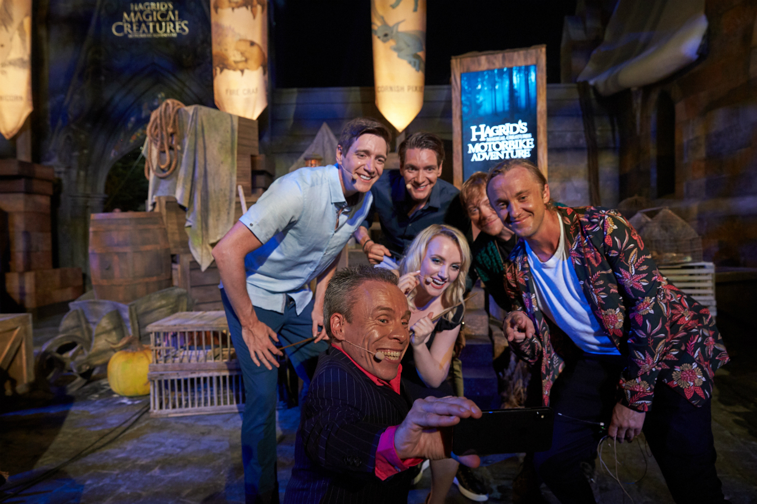 Warwick Davis takes a selfie with James and Oliver Phelps, Evanna Lynch, Rupert Grint, and Tom Felton after the conclusion of the opening celebration event.