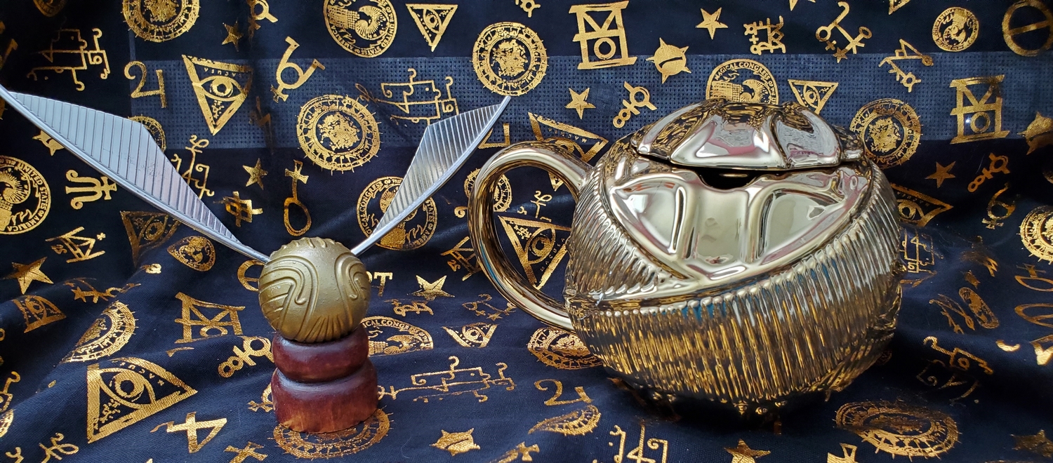 Golden Snitch toy, pictured with the Harry Potter Golden Snitch Coffee Mug from Hallmark Gold Crown