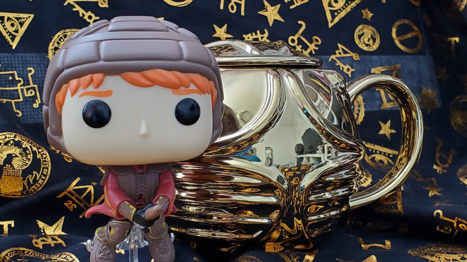 Ron Weasley Funko POP!, pictured with the Harry Potter Golden Snitch Coffee Mug from Hallmark Gold Crown, lid on, back view