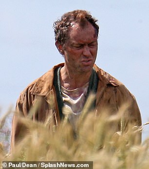 Jude Law appears bloodied, beleaguered, and bedraggled during filming for “The Third Day”.