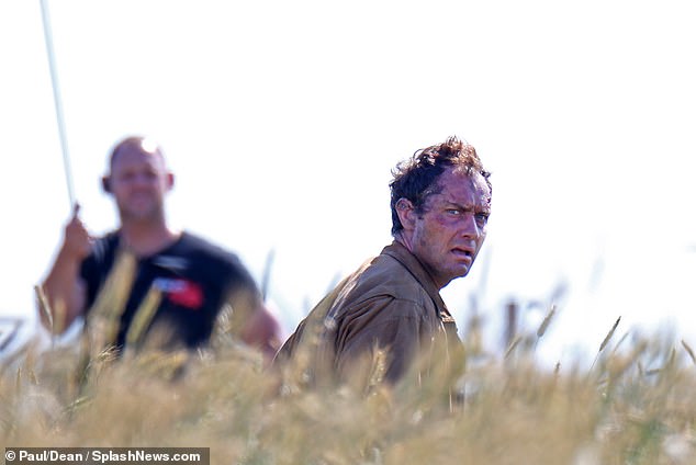 Jude Law appears bloodied, beleaguered, and bedraggled during filming for “The Third Day”.