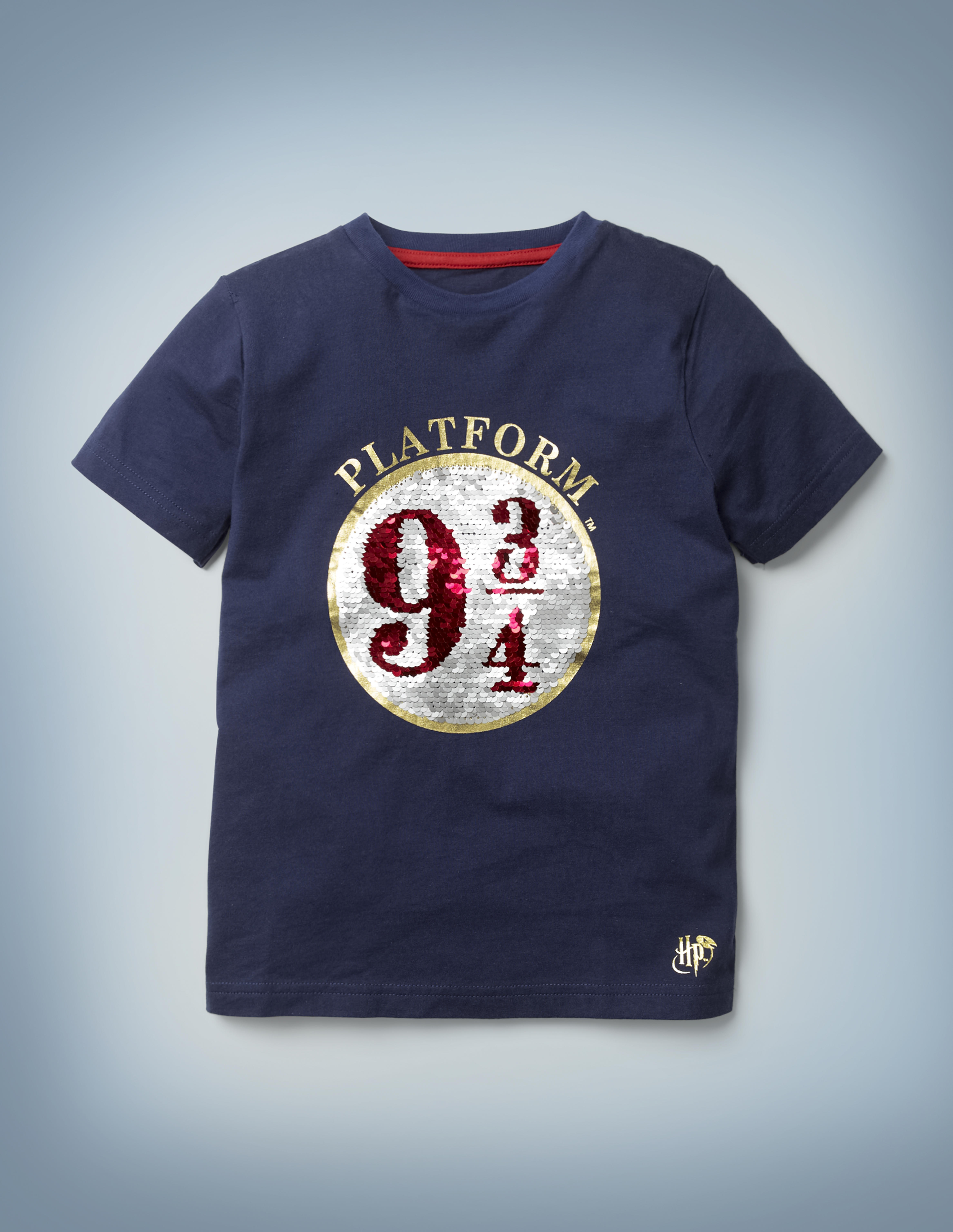 The Mini Boden Platform 9 ¾  Sequin T-shirt in blue features an eye-catching graphic of the circular 9 ¾ sign in silver and red sequins. It retails between £20 and £22.