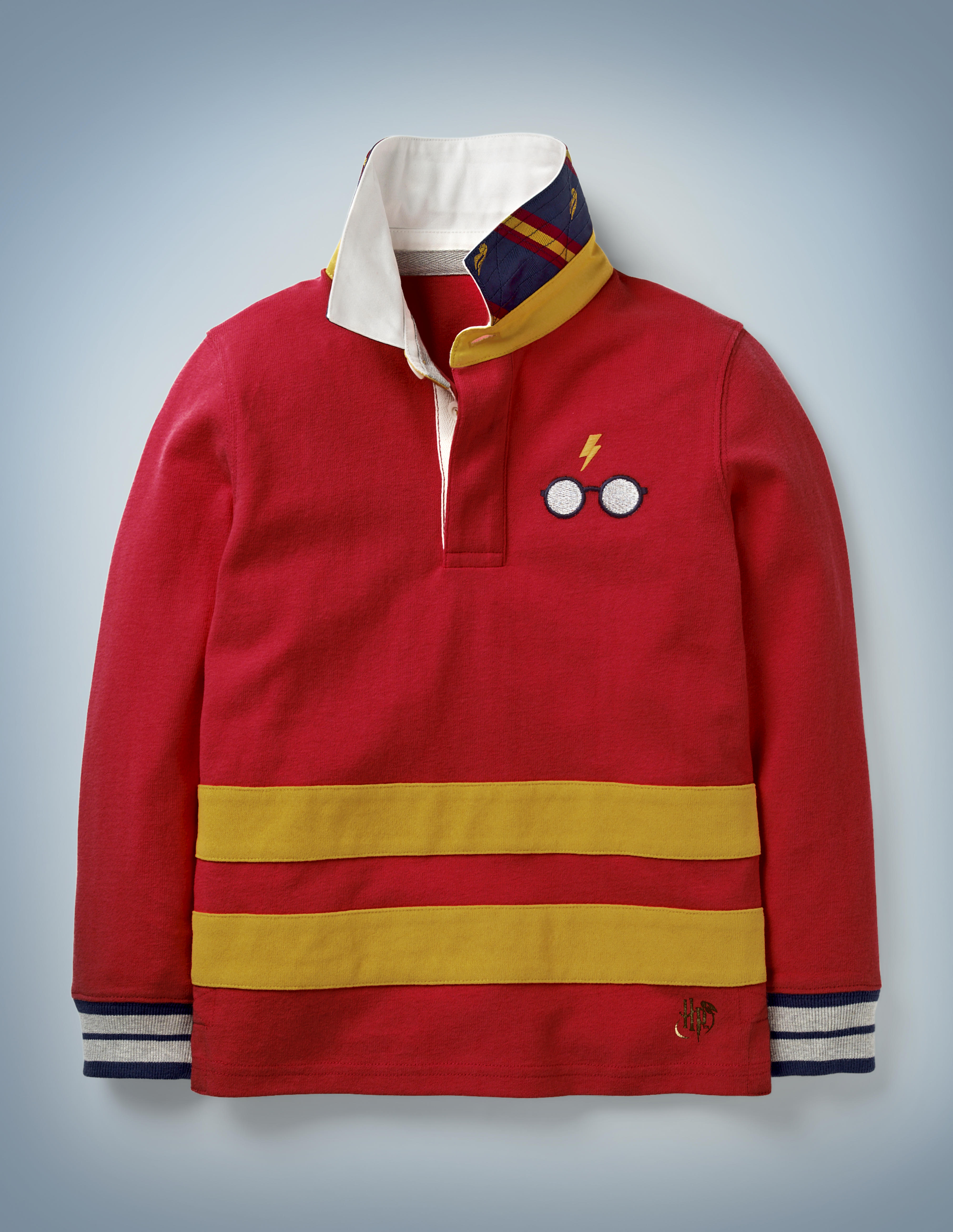 The Mini Boden Hogwarts Rugby Shirt in red is collared with cuffs and features horizontal gold stripes near the hem and a Harry Potter glasses-and-scar design in the front pocket area. It retails at £30.
