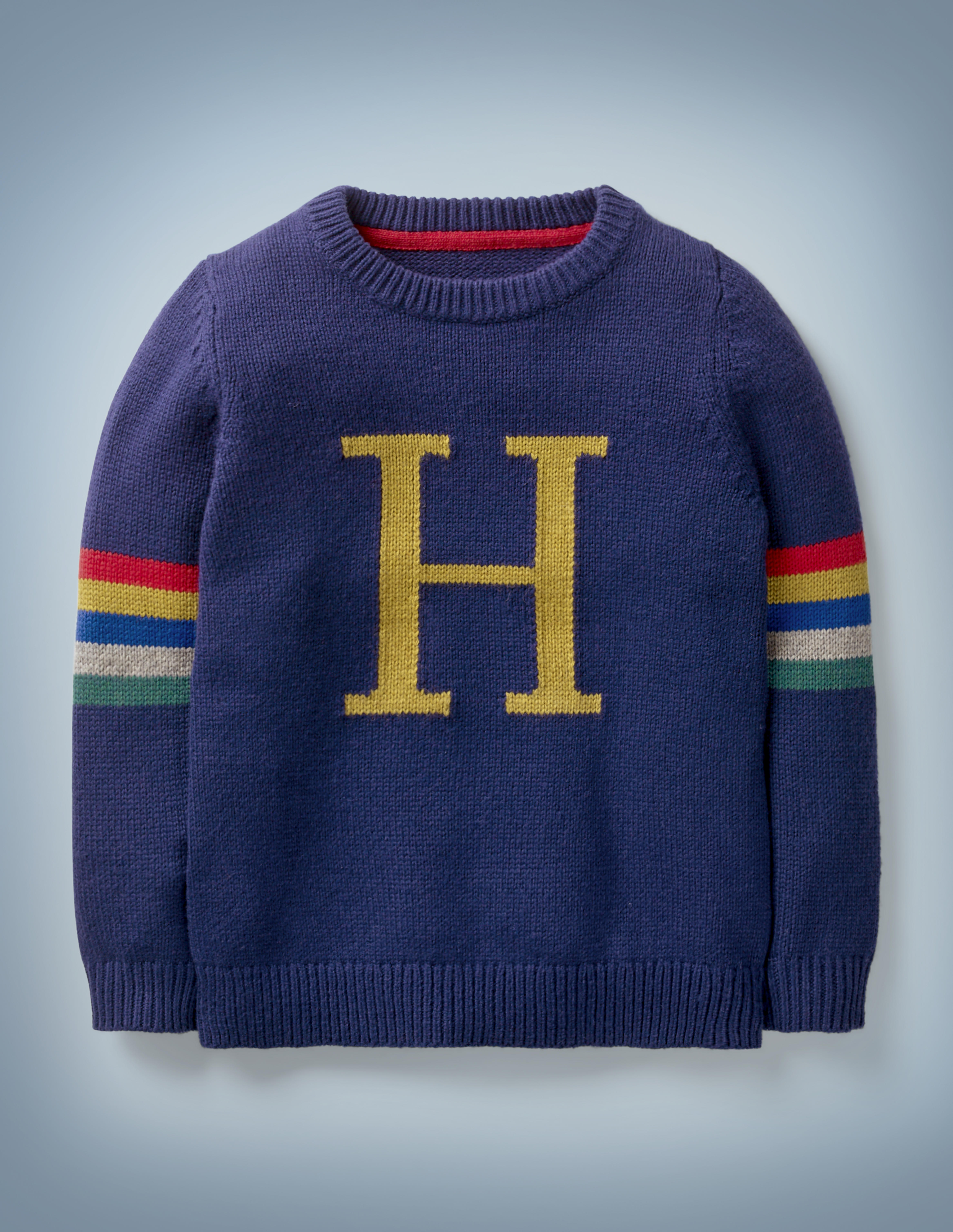 The Mini Boden Harry Potter Knitted Jumper in blue is reminiscent of the Christmas sweater lovingly knitted for Harry by Molly Weasley. It features a large gold “H” in the center with stripes in Hogwarts House colors on both sleeves. It retails between £32 and £37.