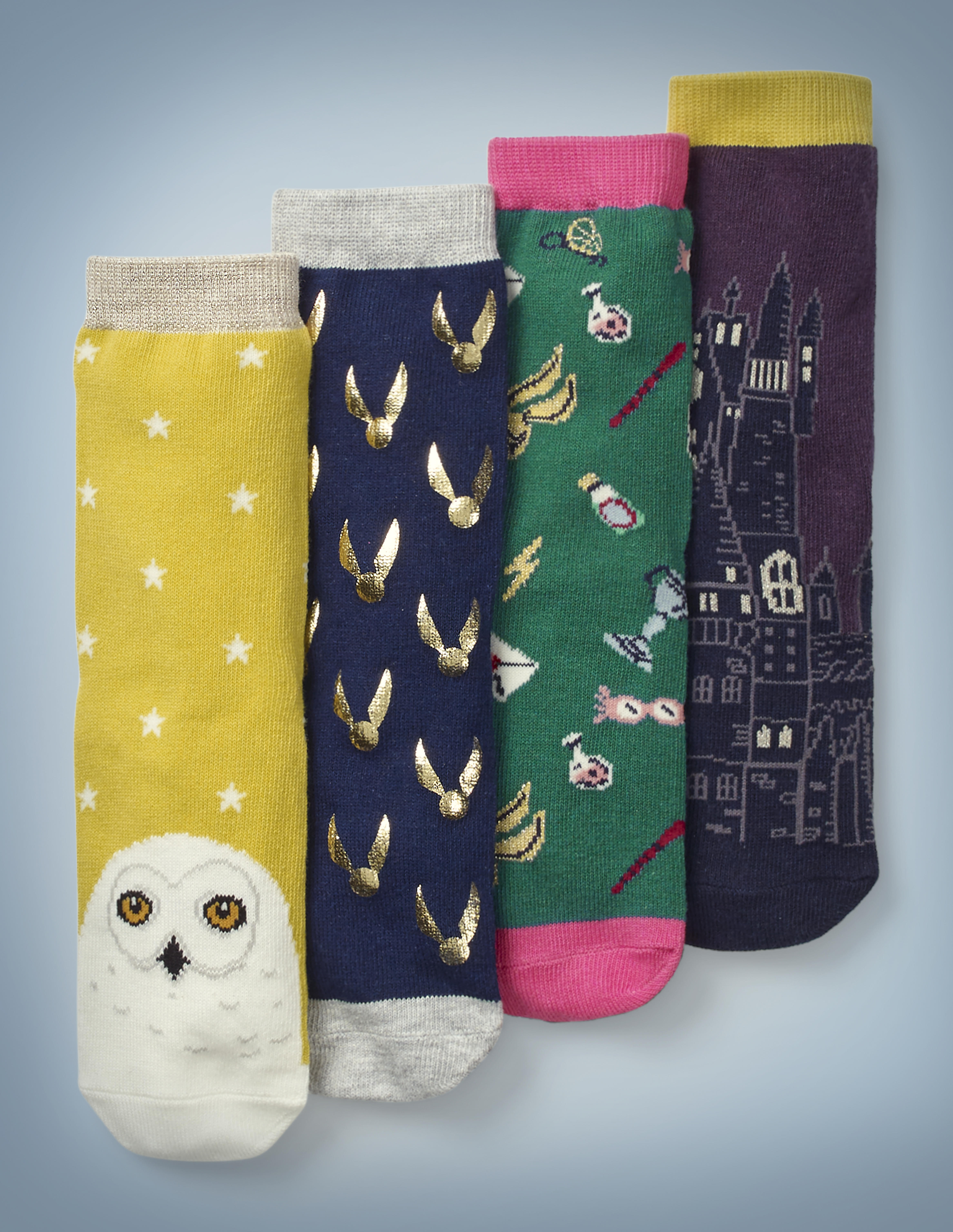 The Mini Boden Pack of Harry Potter Socks features four different designs. Hedwig’s face adorns the toe of a gold pair of socks with a white star pattern. Shiny Golden Snitches cover a navy blue pair. Iconic “Harry Potter” items, such as Luna Lovegood’s Spectrespecs and Hogwarts acceptance letters, cover a green and pink pair. An image of Hogwarts adorns a plum and gold pair. The pack retails at £18.