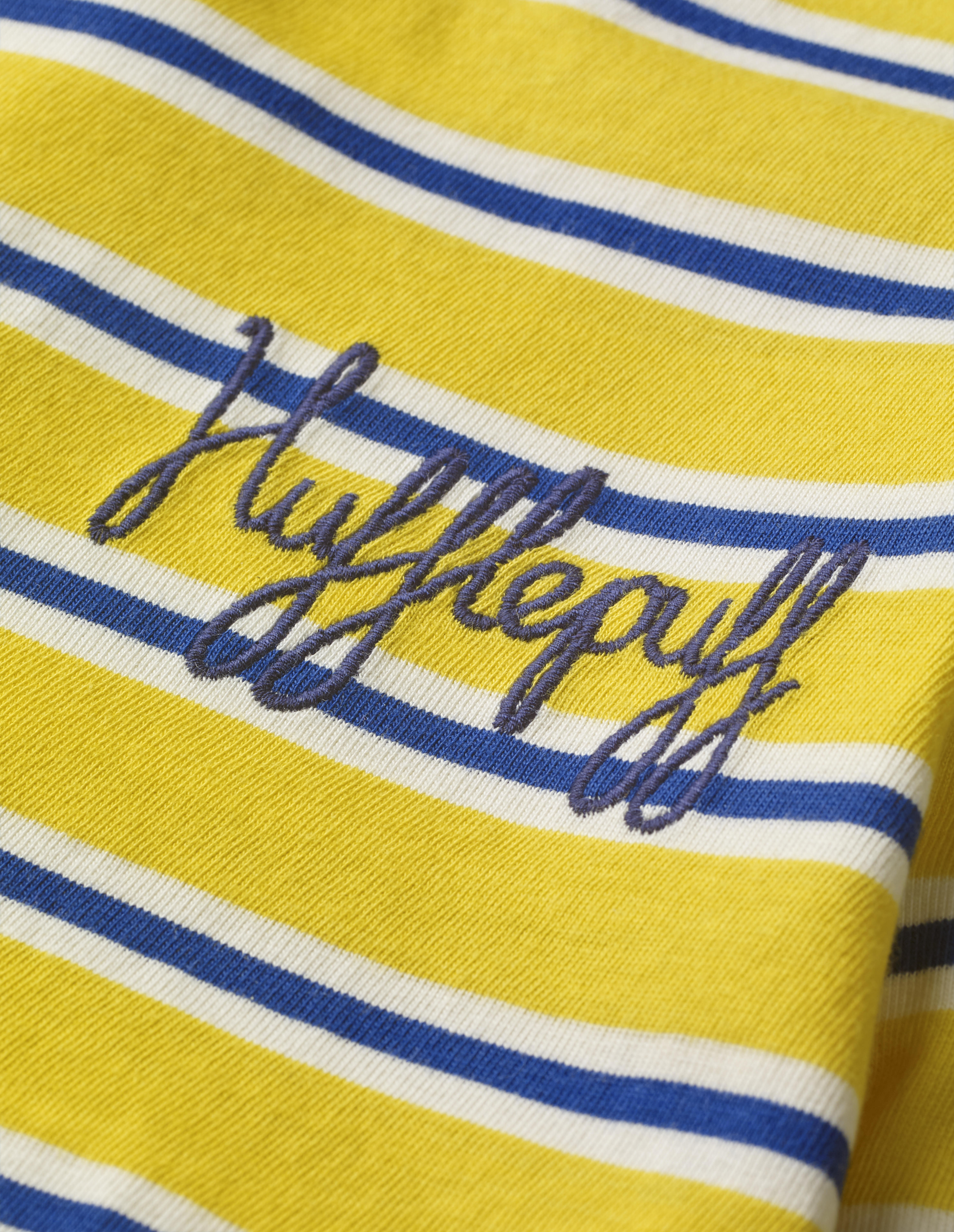 This close-up of the Mini Boden House Breton in yellow better shows the word “Hufflepuff” written in navy blue script in the front pocket area. It retails between £20 and £22.