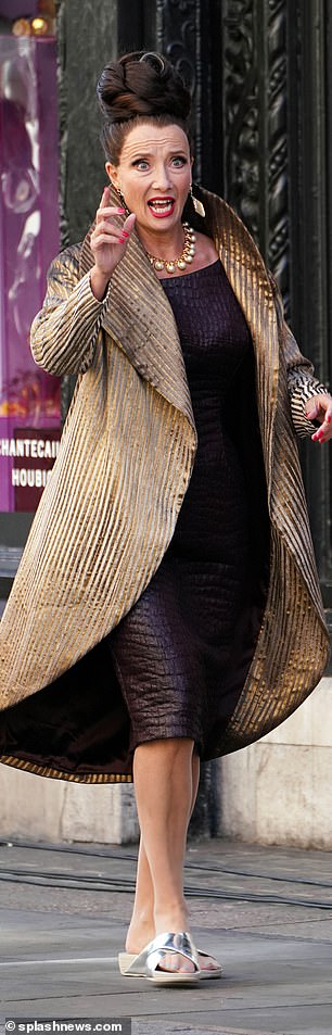 Dame Emma Thompson looks to be hailing a car during filming for “Cruella” last week in London.