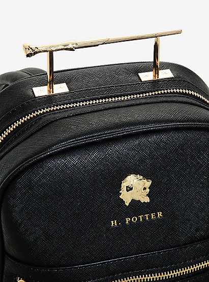 A closer look at the “Harry Potter” wand handle backpack reveals a gold lion’s head, the inscription “H. Potter,” and the handle, created to resemble Harry’s wand.