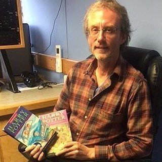 Illustrator Cliff Wright proudly holds two Harry Potter books