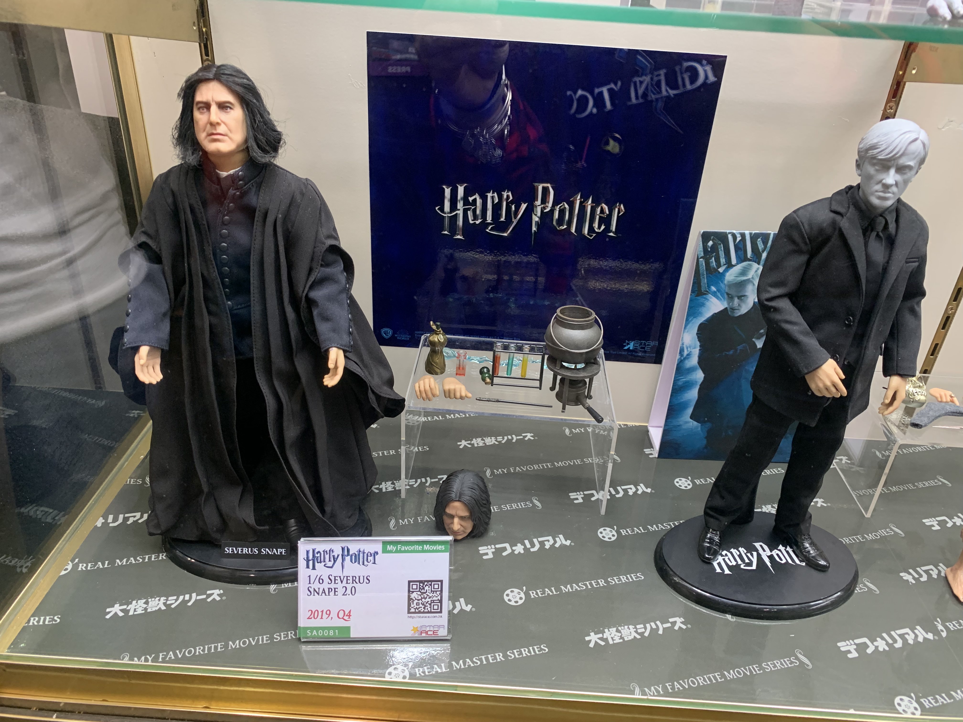 Figurines of Snape and Draco stand beside each other.