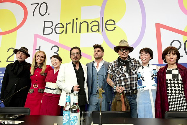 Johnny Depp poses with some of his “Minamata” castmates at the BIFF.
