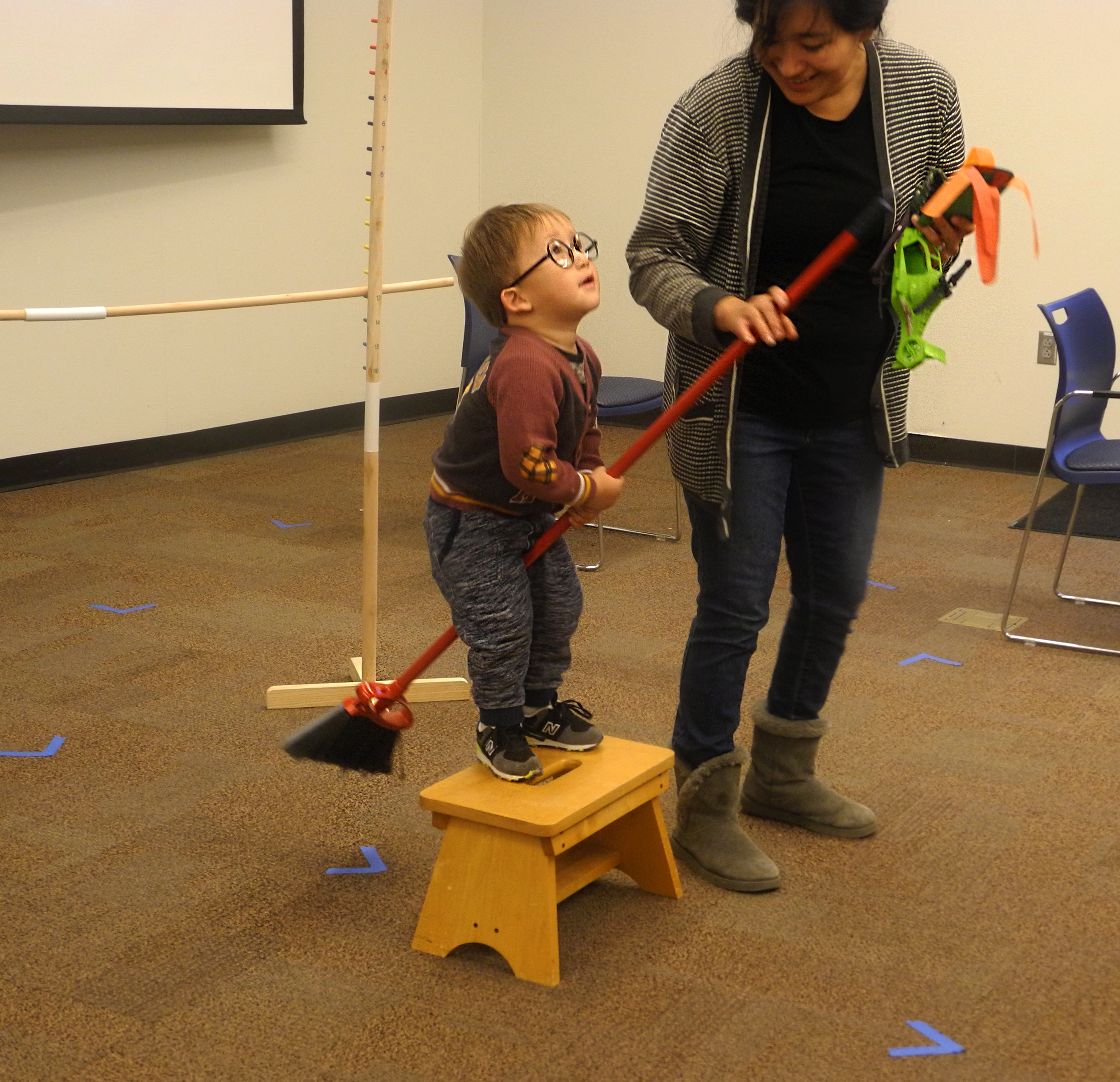 A young boy channels his inner Harry Potter before hopping off a stool on his broom at a Harry Potter Book Night event.