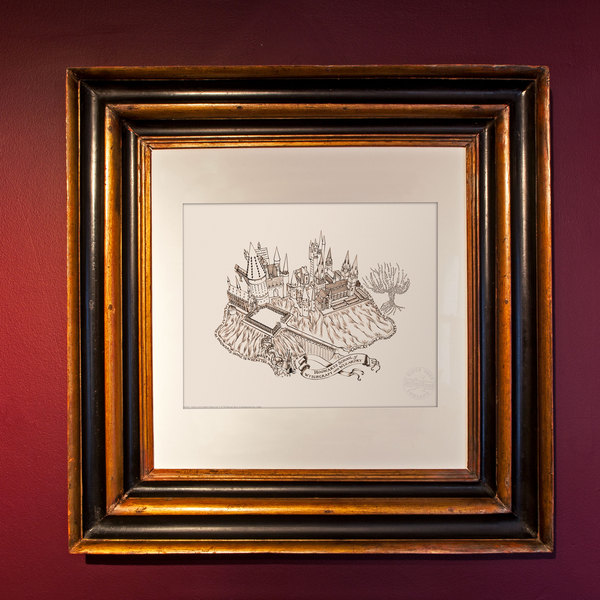 There is a framed print of the Hogwarts grounds in brown ink on white paper. The picture is hanging on a burgundy wall.