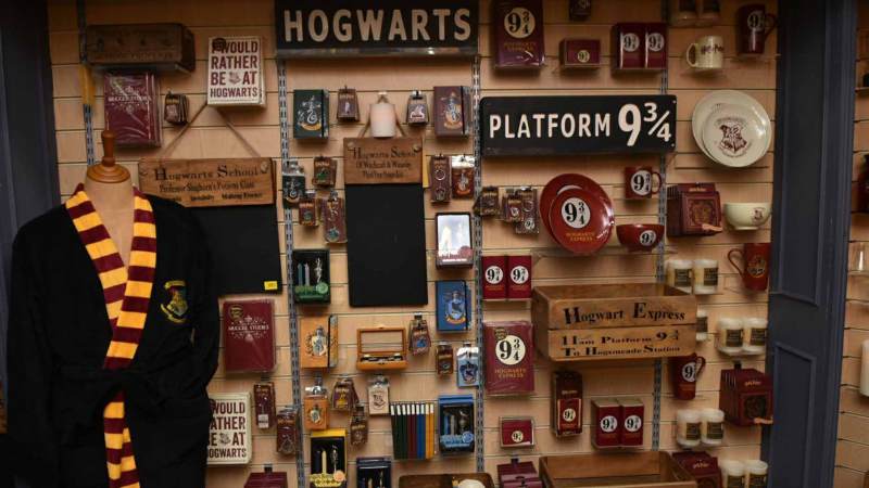 There is a shop wall full of cool Harry Potter items such as plates, signposts, and keychains.