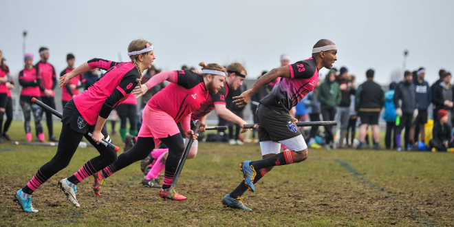 There are four running players in pink jerseys.