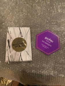 Wizarding World wrapped package with Harry Potter Fan Club Pin Seeking card