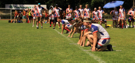 Five players in British jerseys are shown kneeling on the starting line and preparing to run. One of them, a girl on the right, is shouting something. 17 other players are shown in a sub box in the background.