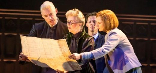 Cursed Child actors playing Draco Malfoy, Minerva McGonagall, Harry Potter, and Ginny Weasley are on stage looking at the Marauder's Map.