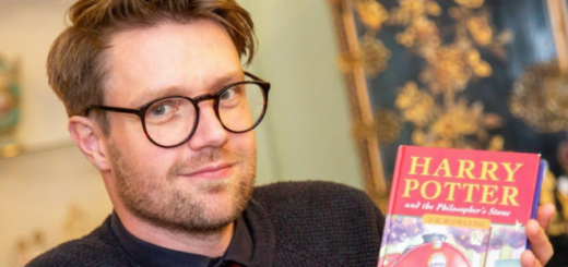 Jim Spencer, of Hansons Auctioneers, poses with a copy of "Harry Potter and the Philosopher's Stone" in a photograph.