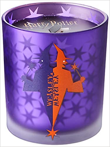 The Weasleys' Wizard Wheezes Glass Candle from Insight Editions is shown as pictured on Amazon. It has a purple and orange holder featuring the Weasleys' Wizard Wheezes logo from the films.